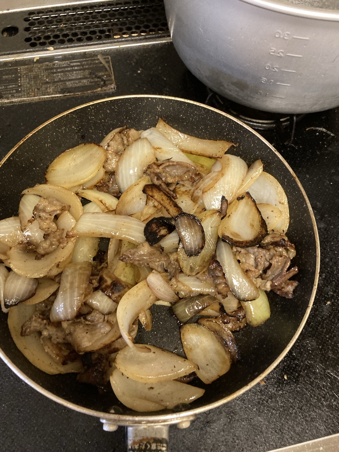 豚バラと玉ねぎに強い焼き色が付き、一部が黒く焦げ始めている様子