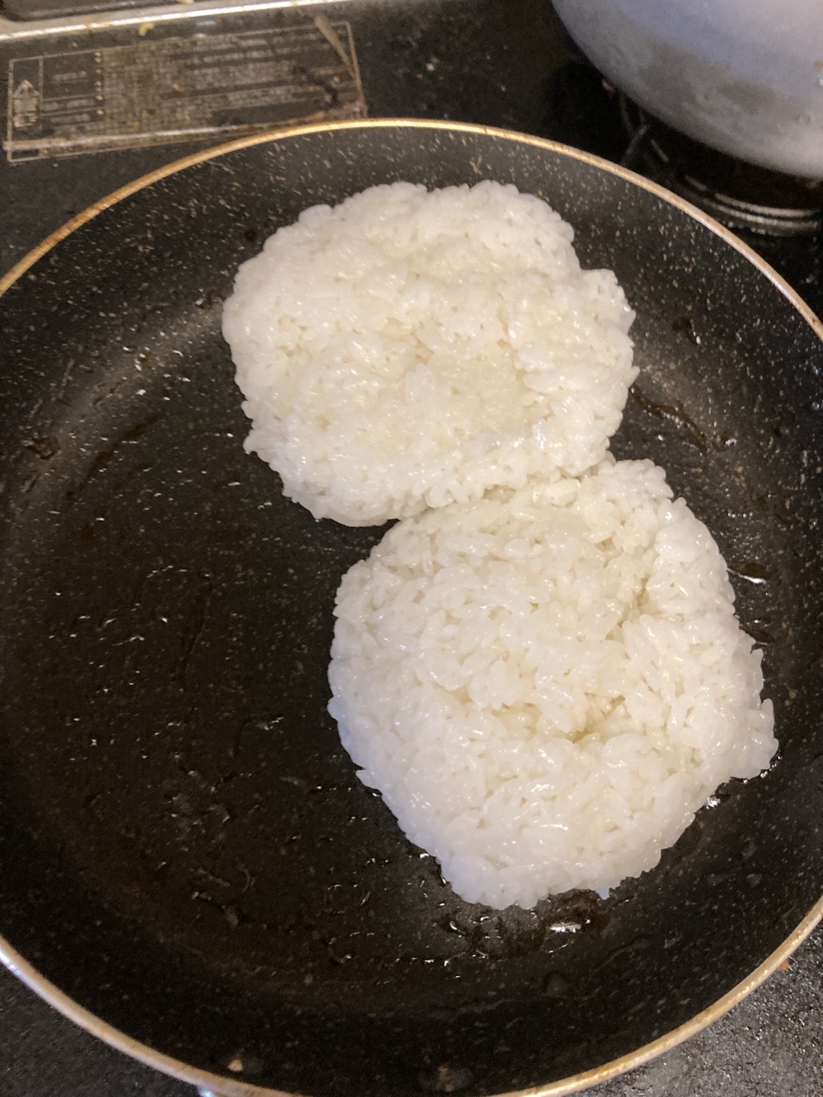 具を取り出したフライパンに白ご飯を入れ、残ったタレと豚脂を吸わせようとしている様子